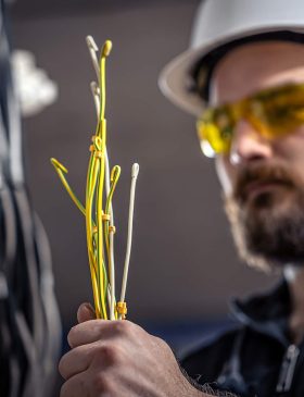 a-male-electrician-works-in-a-switchboard-with-an-2023-11-27-04-58-33-3GF6K82.jpg